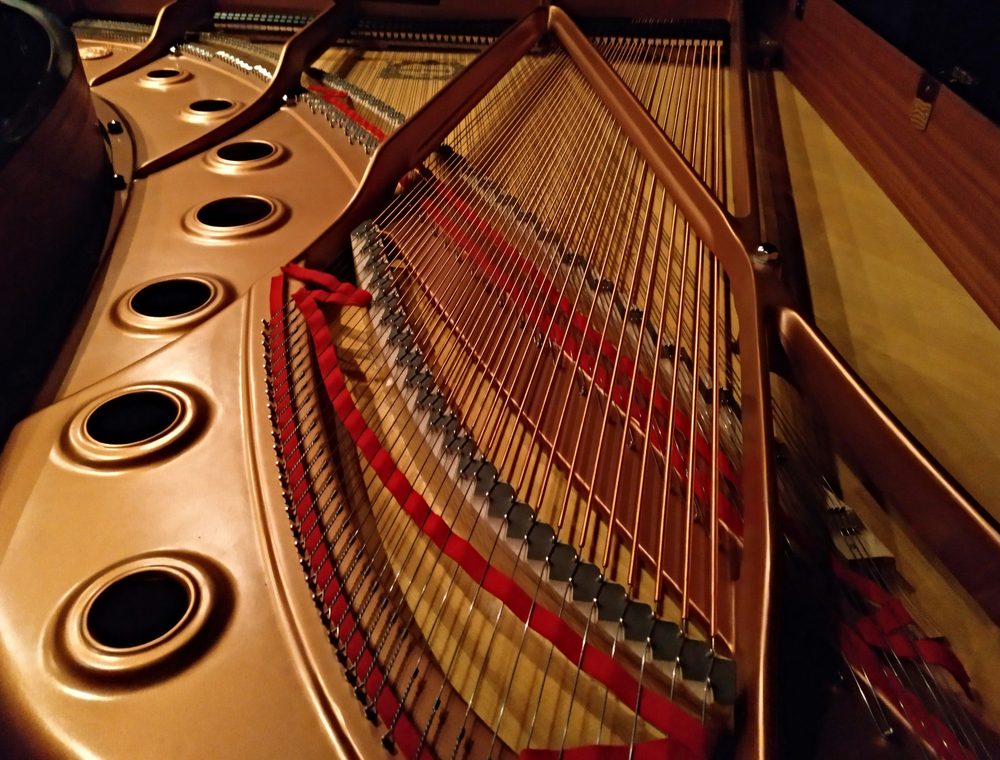 The strings and cast-iron plate inside a grand piano